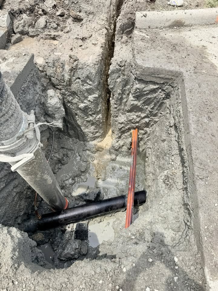 Vacuum excavation hose potholing to verify the exact location and depth of a buried utility pipe before construction